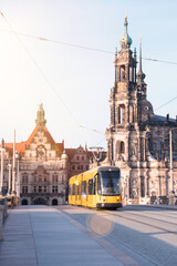 Obraz premium A yellow tram runs over a bridge in the city center of Dresden.