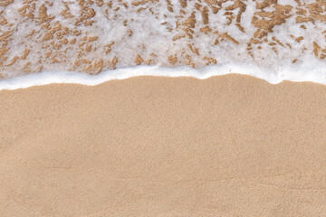 Beach on aerial drone top view with ocean waves reaching shore, top view photo of an amazingly...