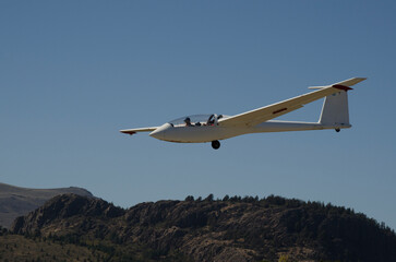 glider flying with mountains in the background