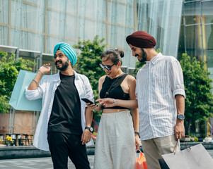 Group Of Happy Friends Having Fun While Shopping And Using Mobile Phone Together Outdoors