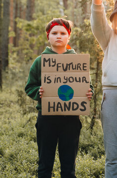 teen boy looking to camera with My Future in Your Hands poster support save planet  movement. youth volunteer protesting for safe ecology, global warming,pollution, plastic pollution. Earth World Day