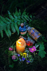 Burning candle, magic witch bottles, flowers on dark forest natural background. Magic ritual, Witchcraft, spiritual practice. pagan, Wiccan, Slavic traditions. esoteric ritual for Midsummer, Litha - obrazy, fototapety, plakaty