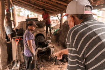 Foreman giving orders to a worker in a mud brick manufacturing workshop in La Paz Centro,...