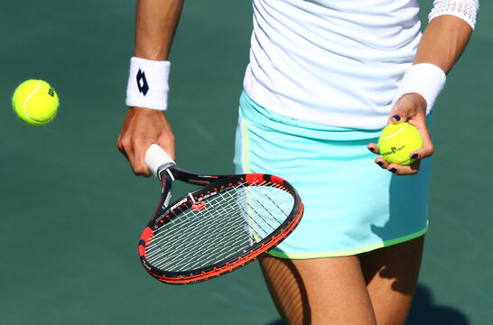 Tennis player prepares to serve a ball