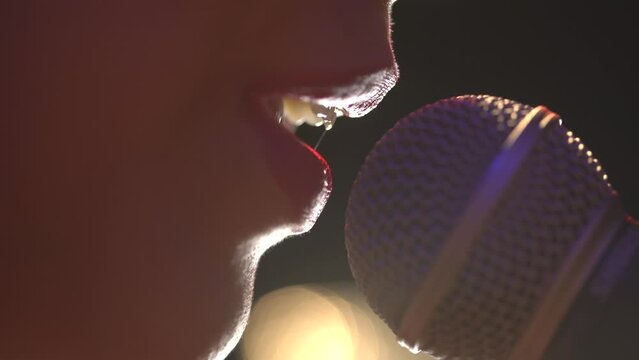 Woman mouth singing to microfone close up