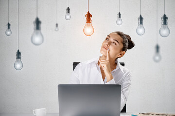 Creative idea and inspiration concept with pensive young woman sitting in front of laptop at light wall background with hanging from the top switched on yellow lightbulb among white lightbulbs