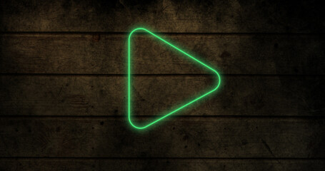 Image of glowing neon arrow icon on brick wall
