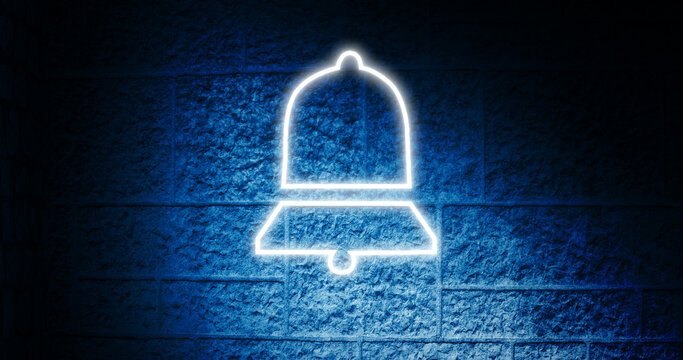 Image of glowing neon bell icon on brick wall