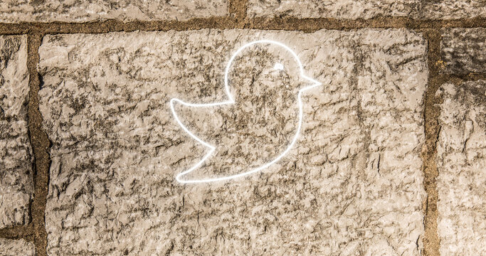Image of glowing neon bird icon on brick wall - Powered by Adobe