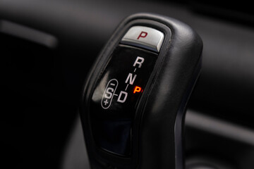 Close-up on automatic transmission lever in modern car. Car interior details. Transmission shift....