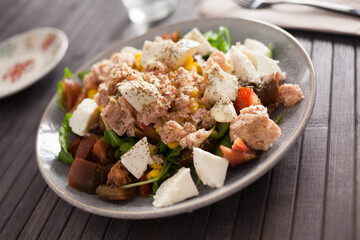 Fish salad with canned tuna and corn, tomatoes and arugula