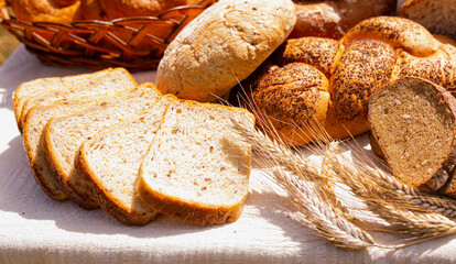 lot of different flavored bread, wheat, rye, on the table in the field outside