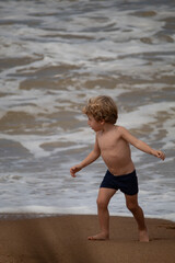 Fototapeta premium MENINO LOIRO BRINCANDO NA PRAIA 