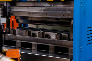 hydraulic press brake or bending machine for flat sheet metal. Worker bending sheet metal on the...