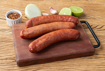 Calabrese pork sausage over wooden board with seasonings