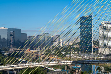 Aerial view of the Marginal Pinheiros Avenue, Octavio Frias de Oliveira Cable stayed bridge, Pinheiros River, corporate buildings and skyline of Sao Paulo city in sunny summer day. Brazil.