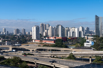 Aerial view of the Marginal Pinheiros Avenue, viaducts car traffic, corporate buildings and skyline of Sao Paulo city in sunny summer day. Brazil.