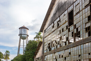Beautiful view of Fordlandia city abandoned building and historic water tank tower in Amazon rainforest, Brazil. Town built by Henry Ford in 1928 to produce rubber in the middle of the forest.	 - obrazy, fototapety, plakaty
