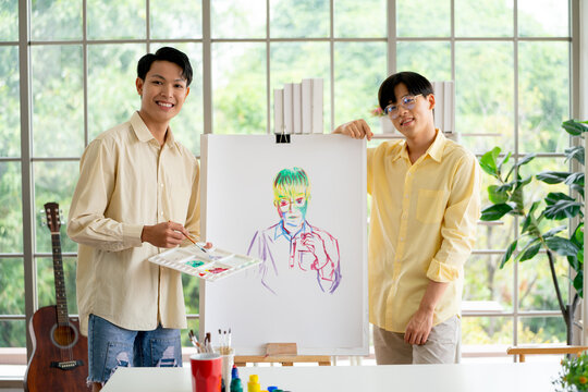 Couple Asian Gay Or Lgbt Man Stand Beside Of Painting That They Make Together In Room Of Their House With Happiness Also Look At Camera.