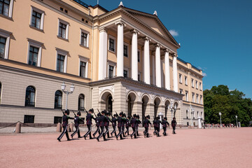 Obraz premium Royal palace in Oslo, Norway with royal guard with riffles and traditional uniform