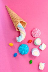 Marshmallows with waffle cone on pink background. Sweets, sugar, candies, marshmallow and ice cream cone. Free copy space, pastel colours.