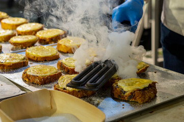 pastry chef caramelizing with electric sugar burner on bun slices