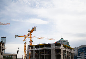 Fototapeta na wymiar The crane carries the slab. Construction of a new apartment building. High quality photo