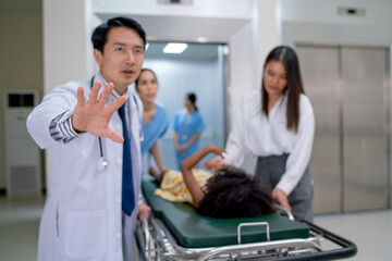 Obraz premium Close up and main focus of doctor hand express to request to clear the way for emergency patient bed after out from elevator in hospital.