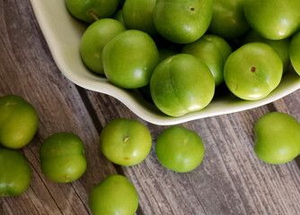 Fototapeta na wymiar green plums on the wooden table