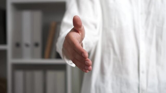 Handshake girl gives a hand. Close-up hand of a man holding out his hand with the aim of getting acquainted. Completion of the deal people handshake successful deal compromise for two people
