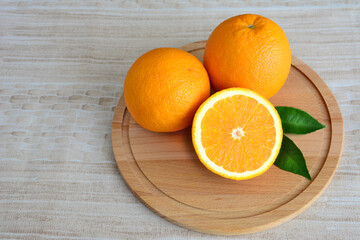 orange fruits on cutting board with green leaves, close-up