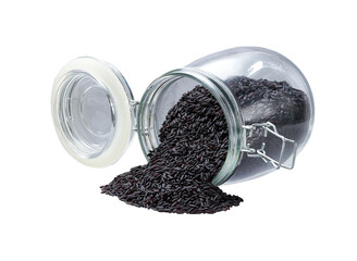 Raw black rice spill out of a glass storage jar isolated on white background.