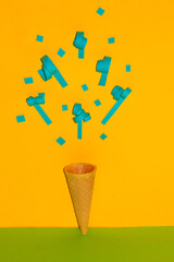ice cream zone from which blue confetti was fired, creative summer party concept, summer tropical vocation, yellow background