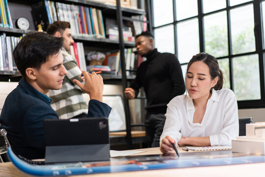 Group of diversity architect designer discuss and critic architecture design project in the office. woman presenting and explaining plan to client or boss. team brainstorming for work process