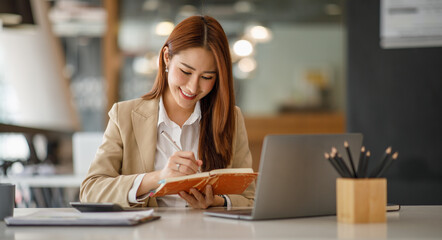 Asian businesswoman working happily about the success of the company,doing planning analyzing the...