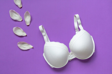 White new bra on a violet background. Bra, lace lingerie on a very peri  purple background. Beauty blog concept. Top view, flat lay 