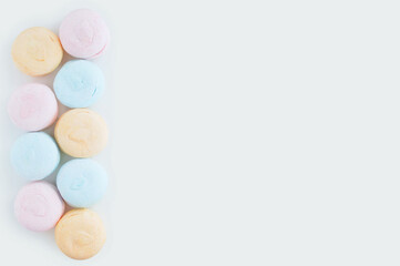 Pastel color marshmallows close-up on white background. Place for text.