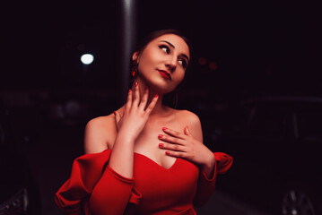 a glamorous woman in a red dress posing in the city