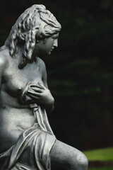 Sculpture of a nude muse posing in a garden
