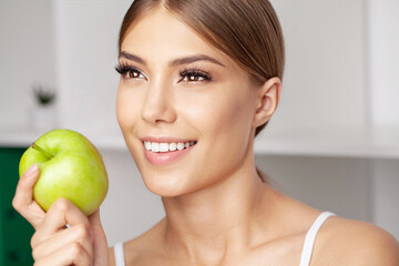 Portrait of open mouthed woman about to bite green apple