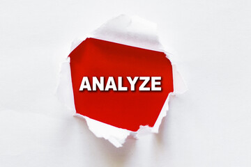 Analyze word on red background appears under torn white paper.