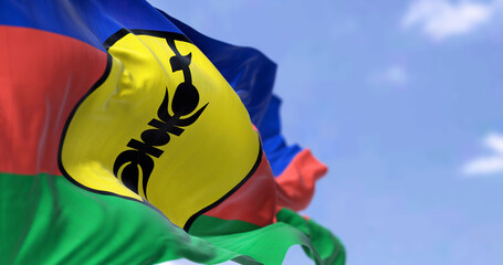 The flag of New Caledonia waving in the wind on a clear day
