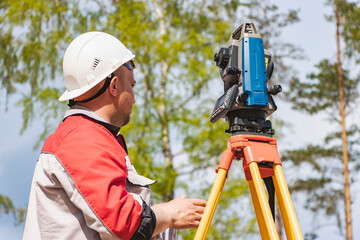 Construction of a residential area. Geodetic stakeout. Surveyor at a large construction site. A man...