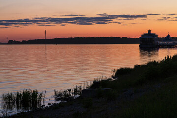 River Volga in Kostroma at sunset with red and orange sky and clouds. Dark silhouettes. Kostroma, Russia