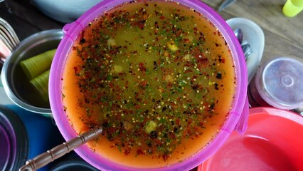 Hot sour spicy sweet liquid In a plastic dish. Making hot sour spicy sweet liquid mixer. Traditional and popular street food item Chotpoti in the Indian subcontinent.