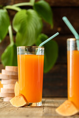 pumpkin juice with orange, orange juice in a glass with a straw, vegetable fresh in a transparent glass, two glasses with juice on a concrete table, sun rays, creative photo of a drink for a magazine,