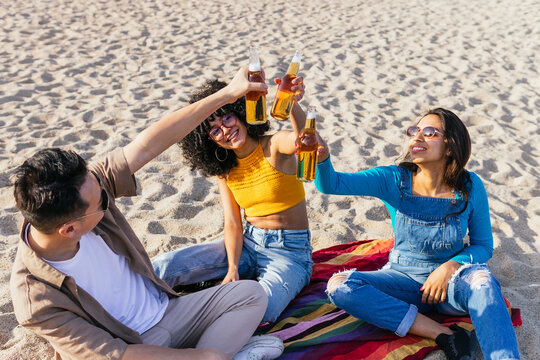 Diverse friends proposing toast on beach