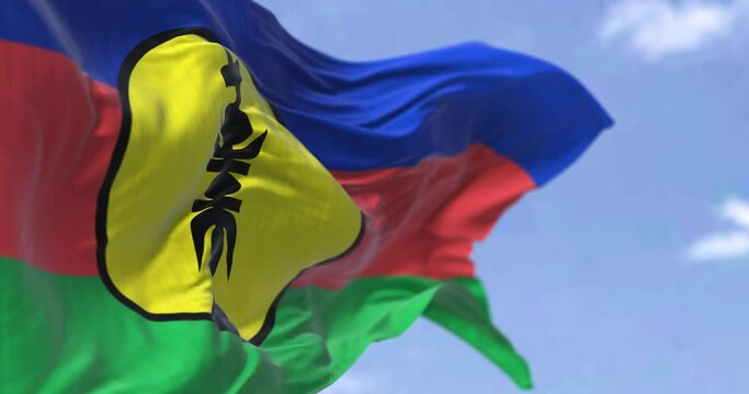 Seamless loop in slow motion of the flag of New Caledonia waving in the wind on a clear day