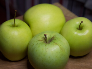 Four large apples, close-up. Fruit on a wooden surface.