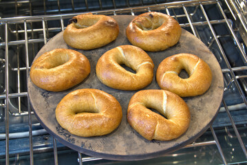Freshly baked Sourdough Bagels on a baking stone in the oven